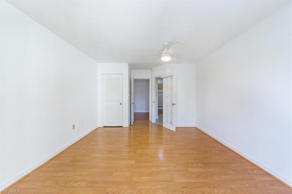 925 Palm View Drive, Unit E118 Naples, FL 34110 - Photo 17 of 26 a view of an empty room with wooden floor