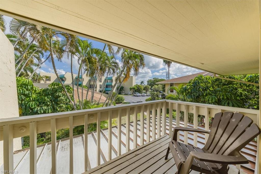 925 Palm View Drive, Unit E118 Naples, FL 34110 - Photo 19 of 26 a view of a chair and table in the balcony