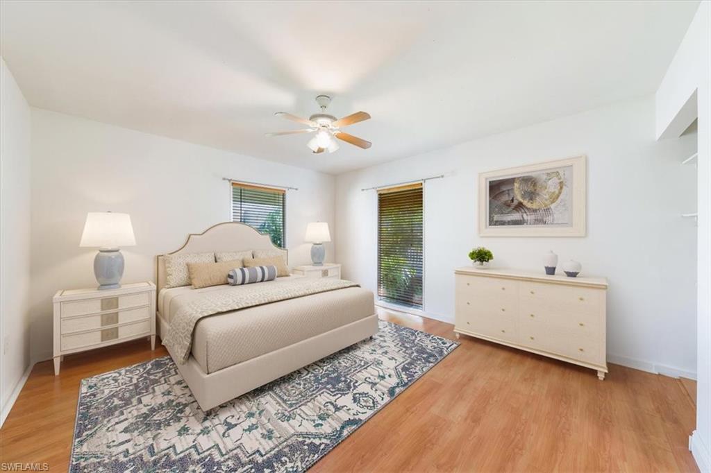 925 Palm View Drive, Unit E118 Naples, FL 34110 - Photo 21 of 26 a bedroom with a bed and a chandelier