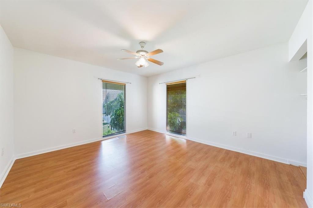 925 Palm View Drive, Unit E118 Naples, FL 34110 - Photo 22 of 26 wooden floor in an empty room with a window