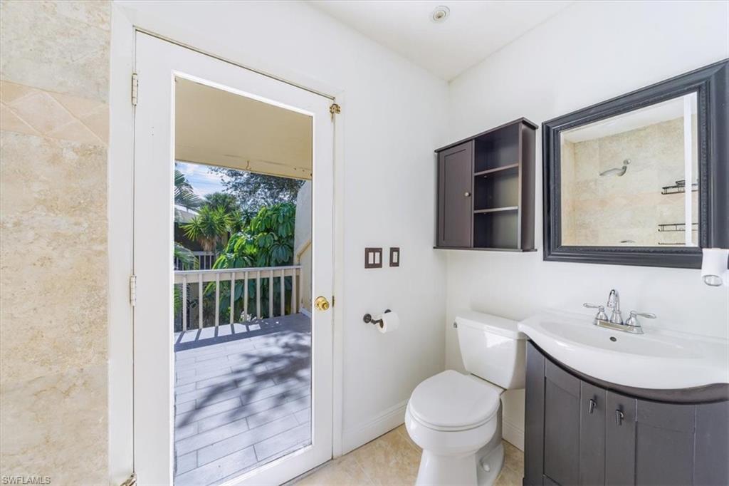 925 Palm View Drive, Unit E118 Naples, FL 34110 - Photo 24 of 26 a bathroom with a toilet sink and mirror