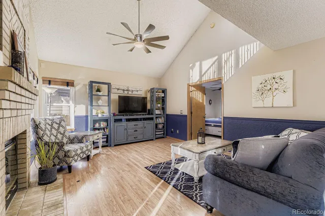 a living room with furniture a flat screen tv and a fireplace
