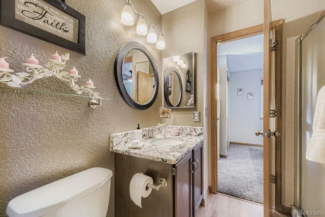 a bathroom with a sink a toilet and a mirror