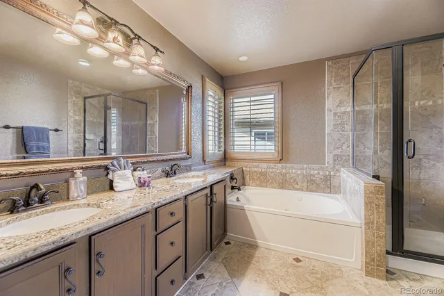 a bathroom with a granite countertop sink mirror and bathtub