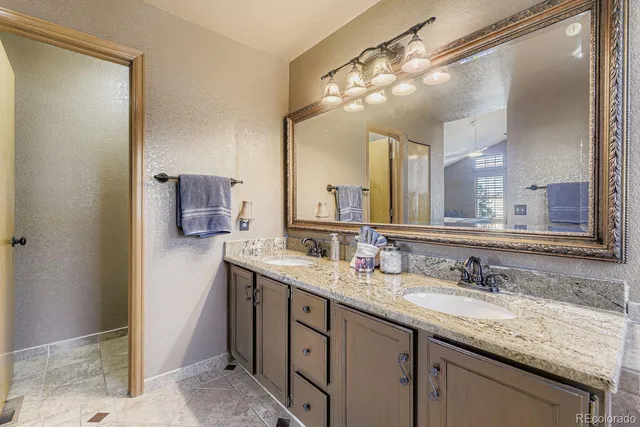 a bathroom with a granite countertop double sink and a mirror