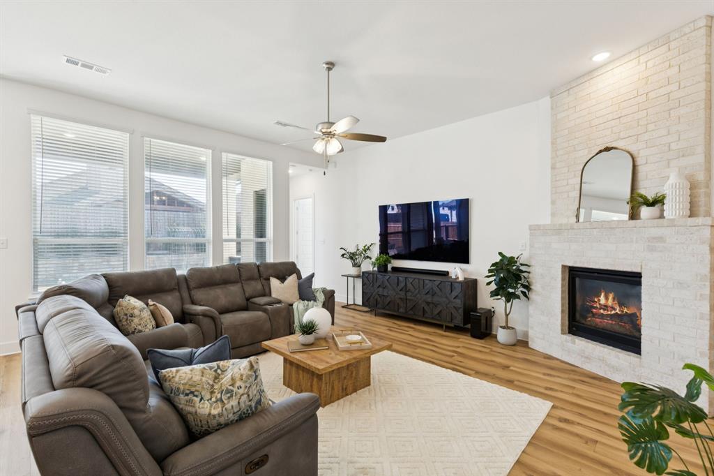 1903 Midhurst Drive Forney, TX 75126 - Photo 11 of 31 a living room with furniture a fireplace and a flat screen tv