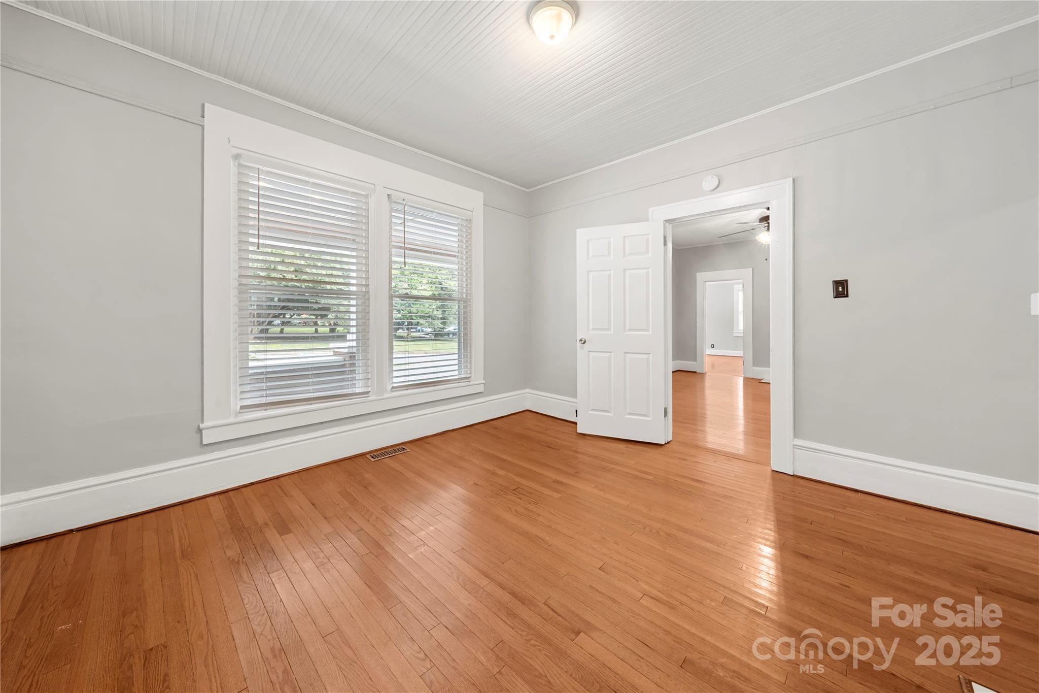 215 West D Street Newton, NC 28658 - Photo 13 of 48 a view of an empty room with wooden floor and a window