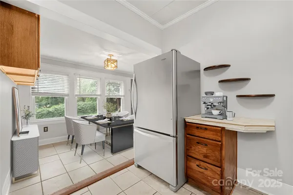 a kitchen with stainless steel appliances a dining table chairs and a refrigerator