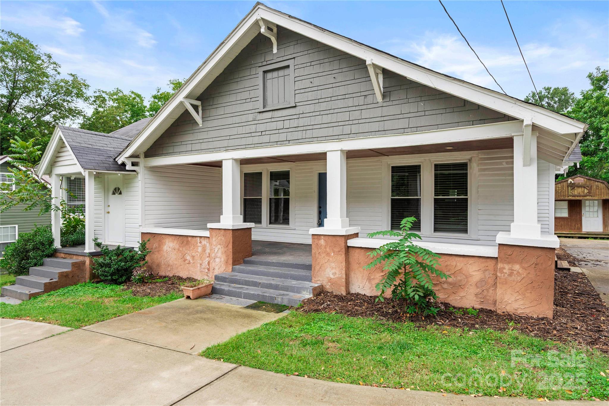 215 West D Street Newton, NC 28658 - Photo 3 of 48 a front view of a house with garden and porch