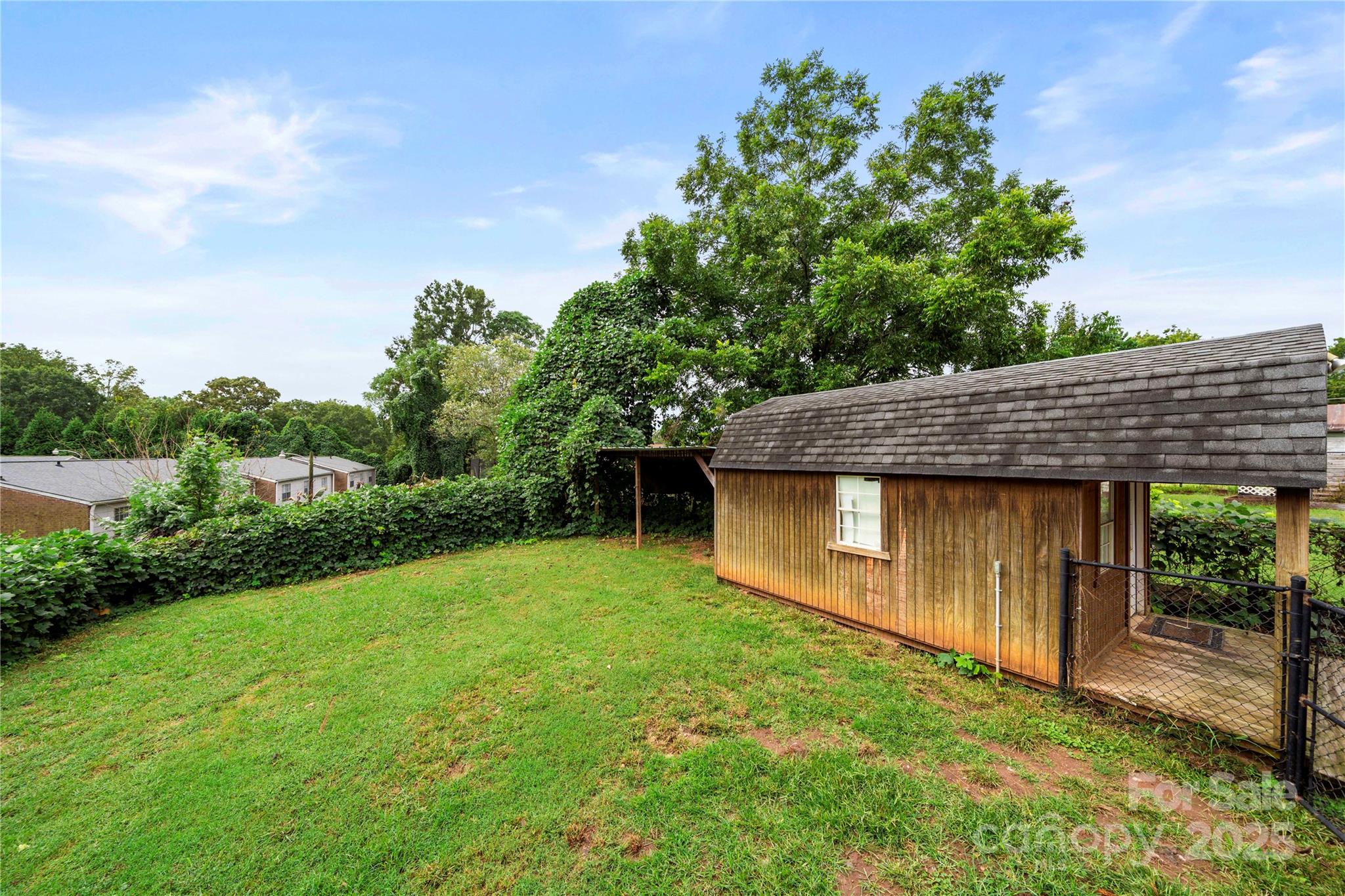 215 West D Street Newton, NC 28658 - Photo 47 of 48 a backyard of a house with plants and wooden fence