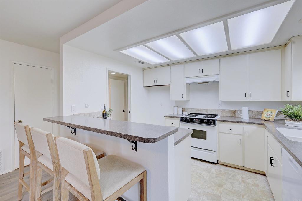 418 3rd Street Encinitas, CA 92024 - Photo 21 of 74 a kitchen with stainless steel appliances a sink a stove a table and chairs