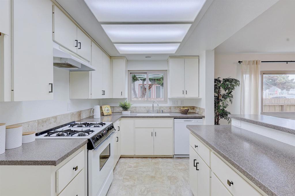 418 3rd Street Encinitas, CA 92024 - Photo 23 of 74 a kitchen with granite countertop a sink stove and cabinets