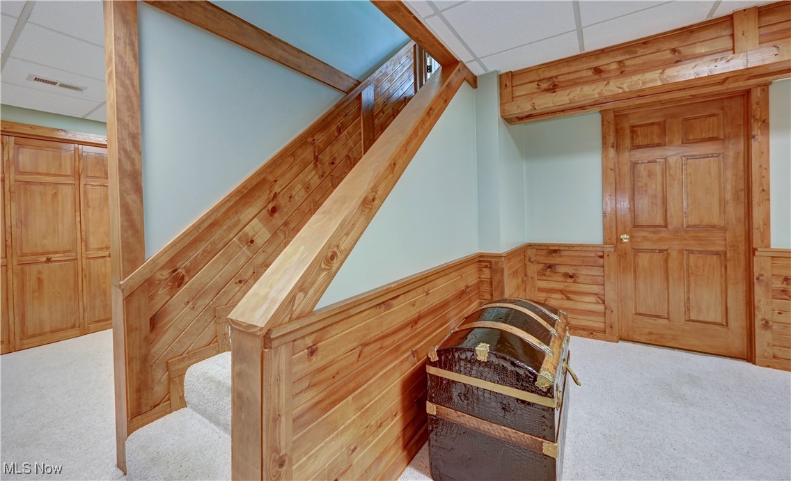 9559 Trail Bottom Road Northwest Dundee, OH 44624 - Photo 26 of 48 Stairs with wooden walls, carpet flooring, a paneled ceiling, and a wainscoted wall