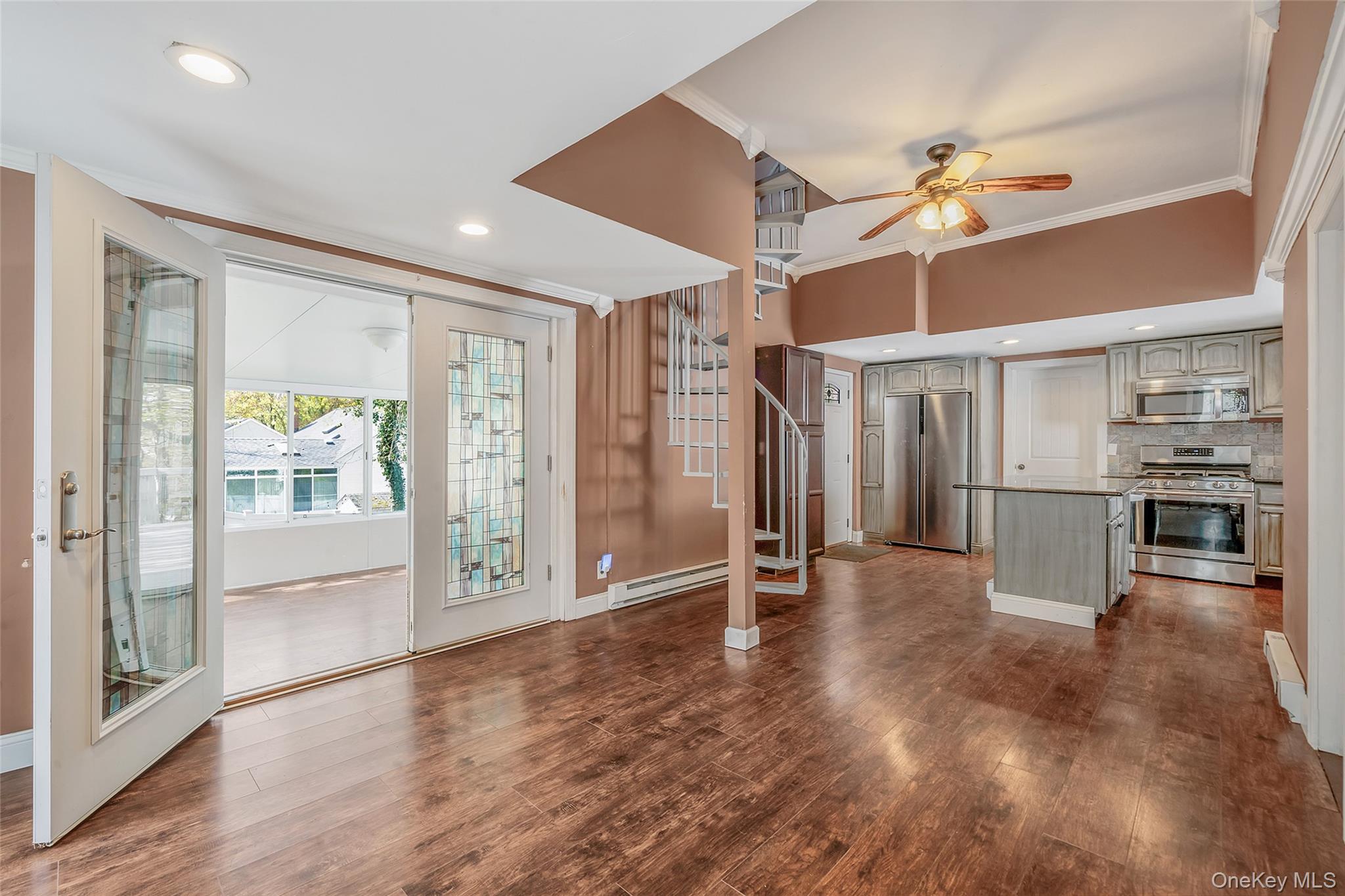 93 Maple Road Kings Park, NY 11754 - Photo 21 of 24 a view of a livingroom with wooden floor and a ceiling fan