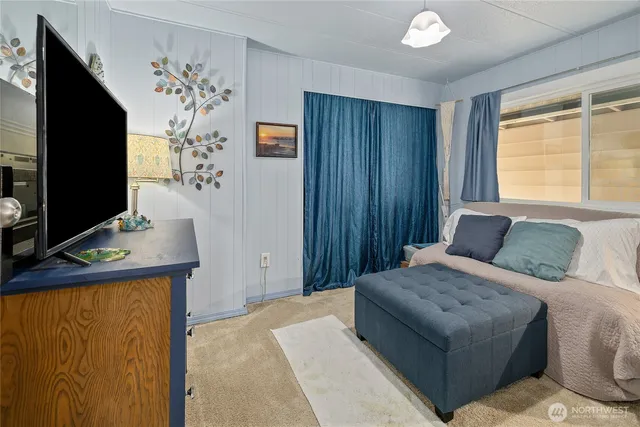 a bedroom with a bed and a flat screen tv