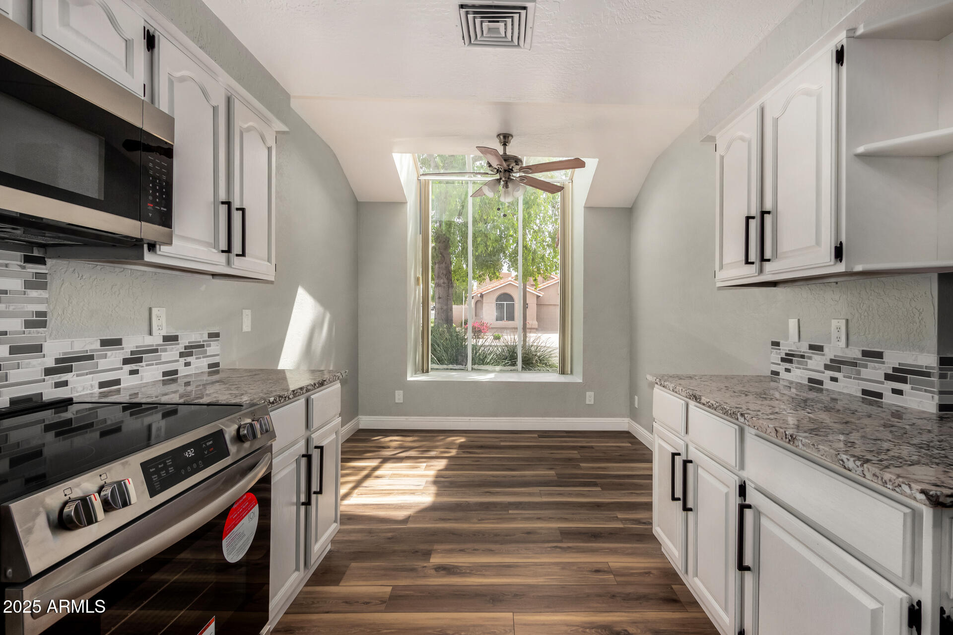 3832 North Gallatin Mesa, AZ 85215 - Photo 21 of 41 a kitchen that has a stove and a white wooden cabinets