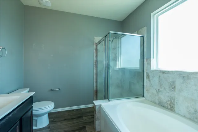 a bathroom with a granite countertop bathtub shower and a toilet