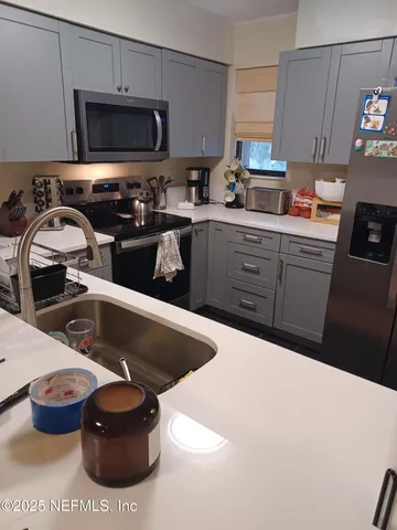 a kitchen with a sink a stove and cabinets