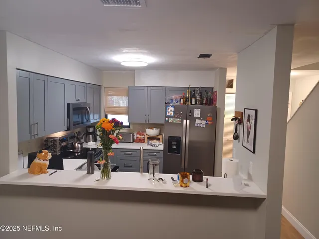 a room with furniture a flat screen tv and a refrigerator