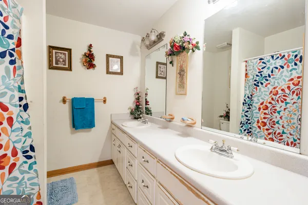 a spacious en suite bathroom with a double vanity sink mirror and