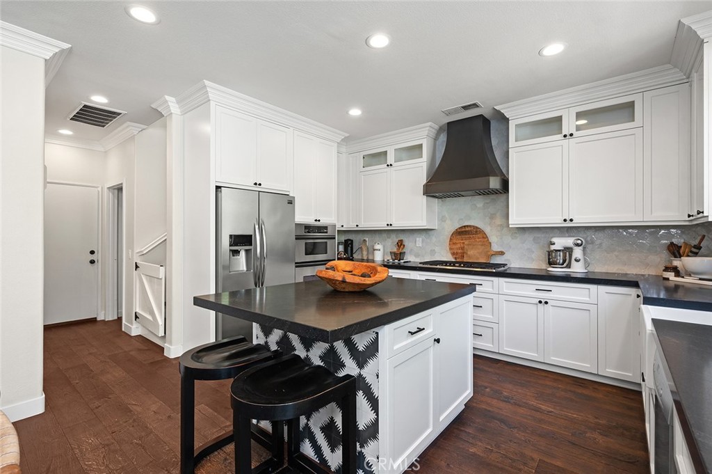 9 Baudin Circle Ladera Ranch, CA 92694 - Photo 15 of 48 a kitchen with stainless steel appliances a sink a stove a refrigerator cabinets and a dining table