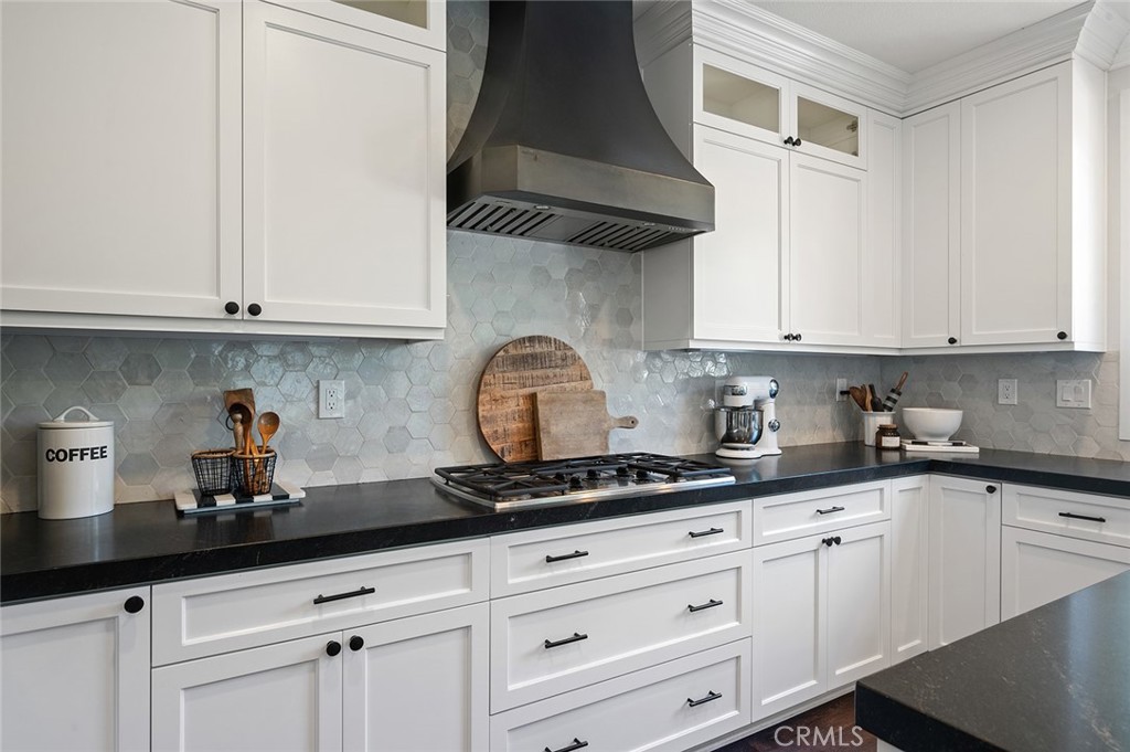 9 Baudin Circle Ladera Ranch, CA 92694 - Photo 16 of 48 a kitchen with granite countertop white cabinets and black appliances