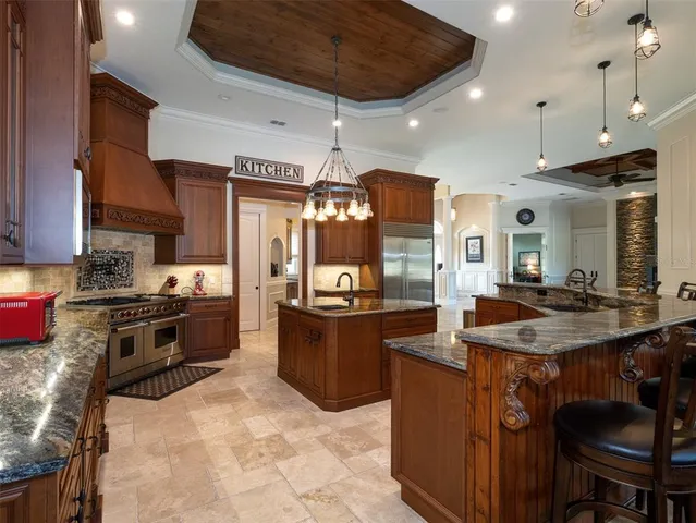 a kitchen with stainless steel appliances granite countertop a stove a sink and a refrigerator