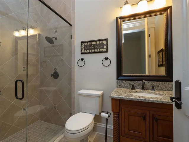 a bathroom with a granite countertop sink toilet and shower