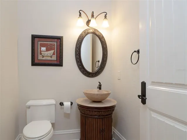 a bathroom with a toilet a sink and a mirror