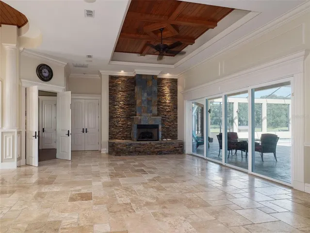 a view of an empty room with a fireplace and a large window