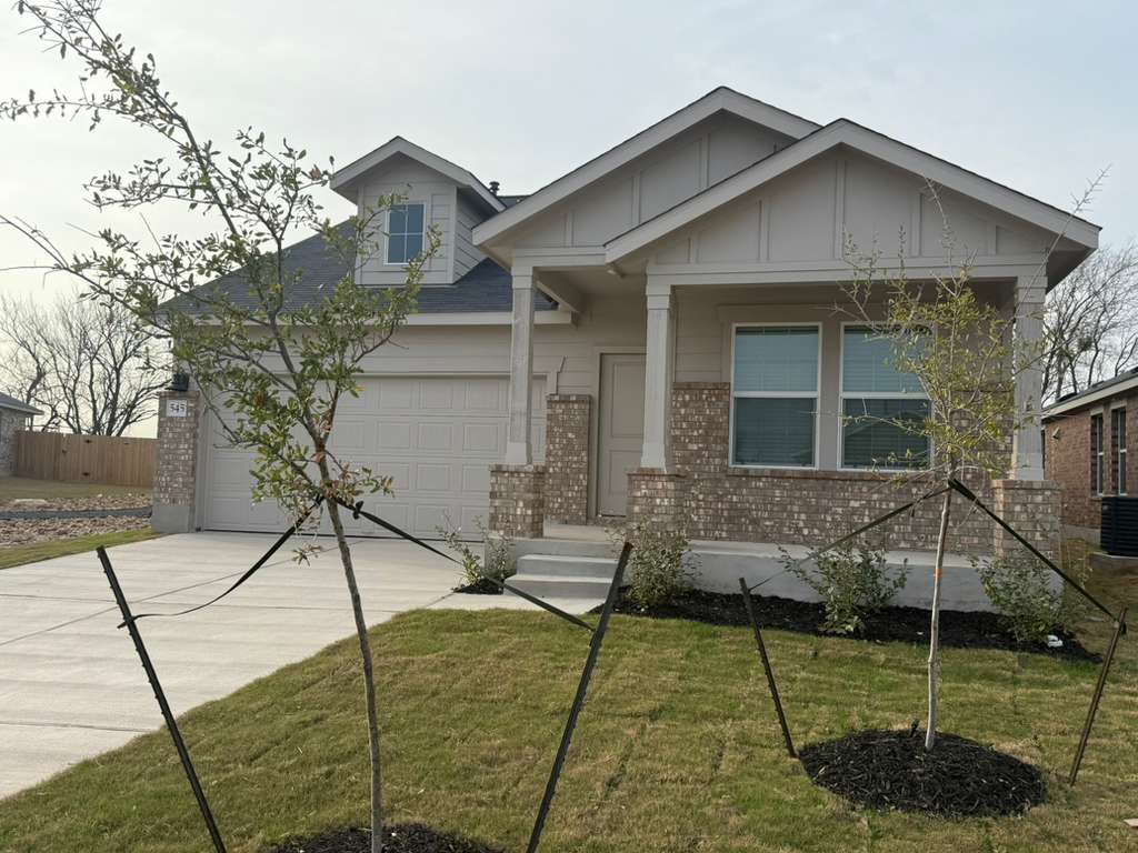 545 Sormonne Loop Kyle, TX 78640 - Photo 5 of 39 View of front facade featuring concrete driveway, brick siding, a porch, an attached garage, and board and batten siding