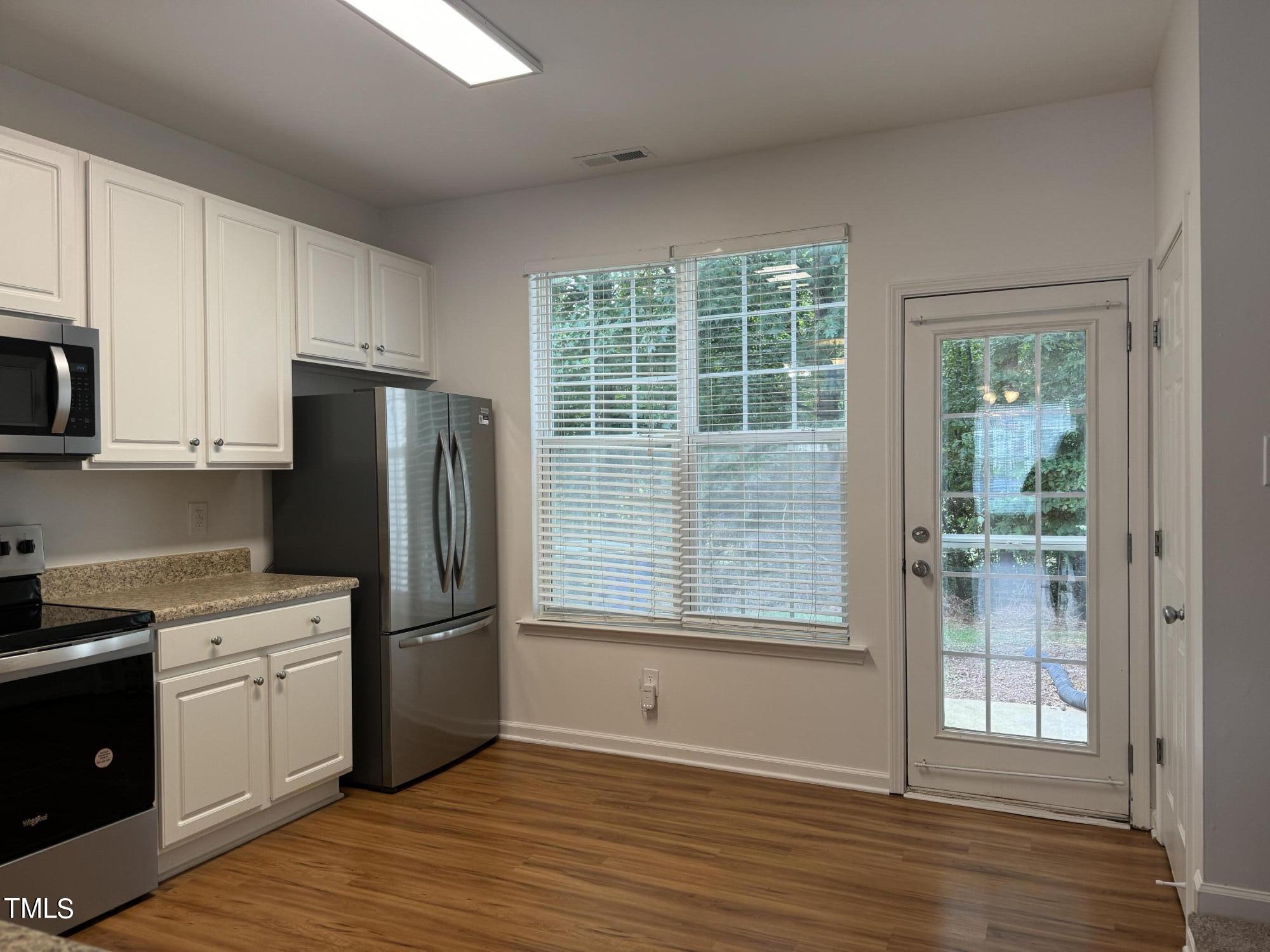 8227 City Loft Court Raleigh, NC 27613 - Photo 11 of 33 a kitchen with a refrigerator and cabinets