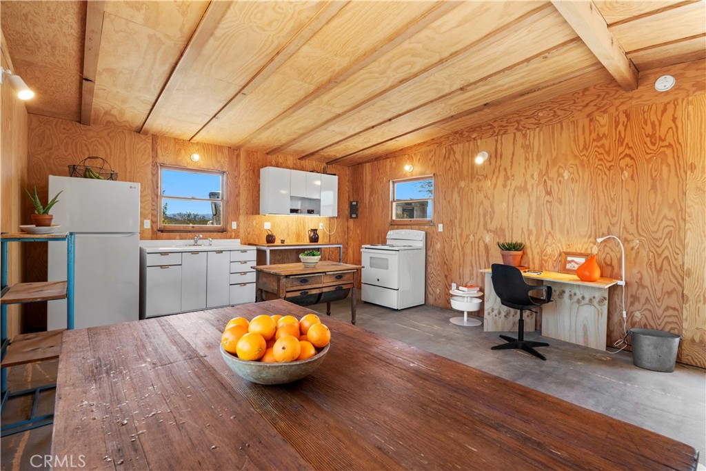 1356 Enchanted Road Joshua Tree, CA 92252 - Photo 11 of 47 a kitchen with stainless steel appliances wooden floors and wooden cabinets