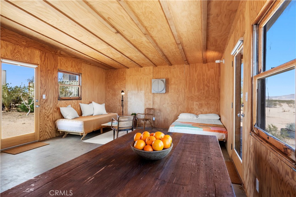 1356 Enchanted Road Joshua Tree, CA 92252 - Photo 17 of 47 a spacious bedroom with a bed and wooden floor