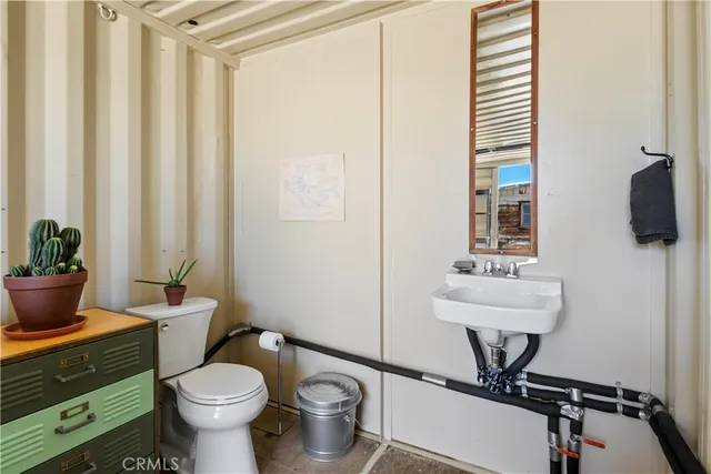 a bathroom with a toilet a sink and a mirror