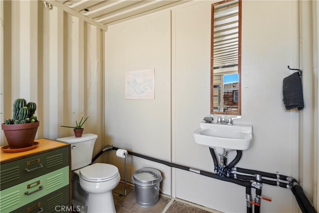 1356 Enchanted Road Joshua Tree, CA 92252 - Photo 30 of 47 a bathroom with a toilet a sink and a mirror