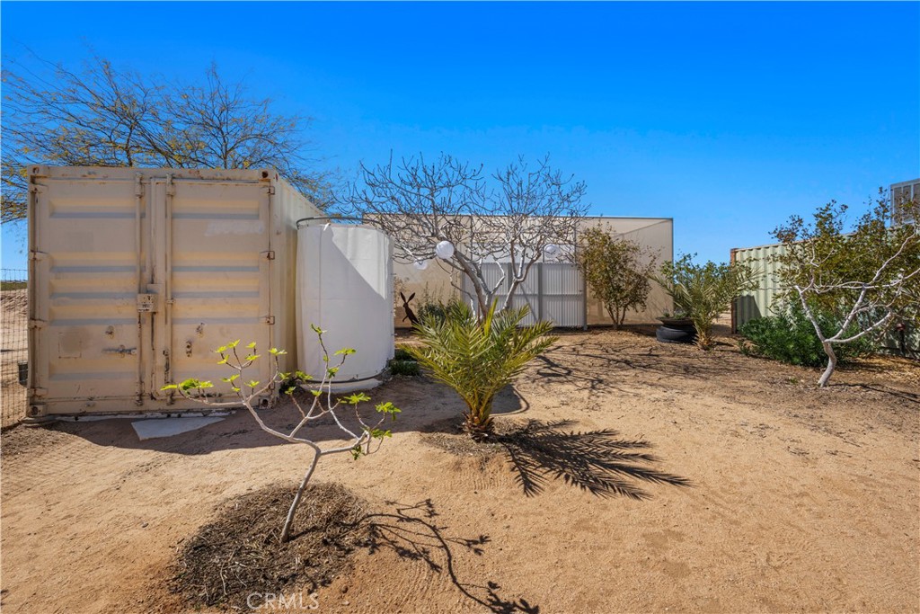 1356 Enchanted Road Joshua Tree, CA 92252 - Photo 33 of 47 a backyard of a house with table and chairs