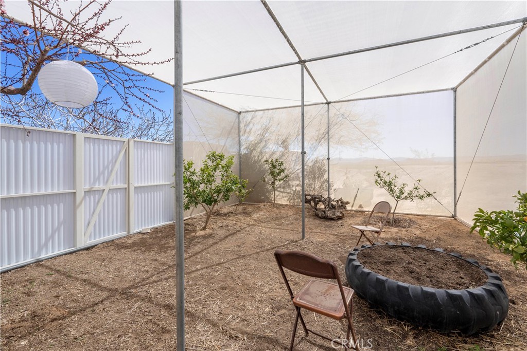 1356 Enchanted Road Joshua Tree, CA 92252 - Photo 36 of 47 a backyard of a house with table and chairs