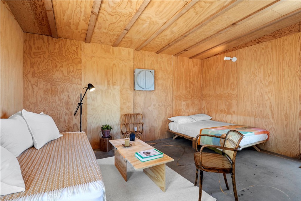 1356 Enchanted Road Joshua Tree, CA 92252 - Photo 10 of 47 a bedroom with furniture and a wooden floor