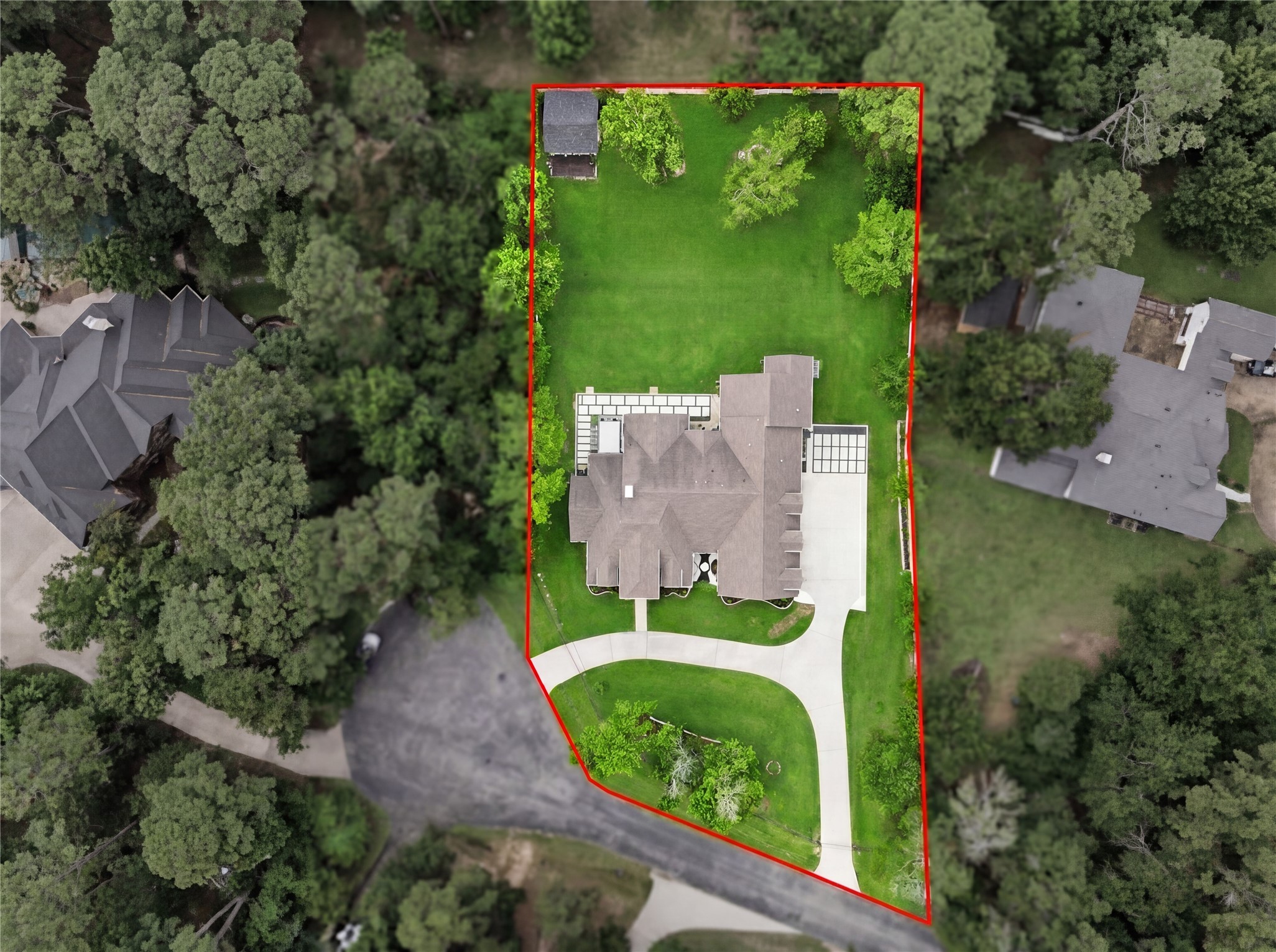 7106 Hampton Court Spring, TX 77389 - Photo 25 of 31 Aerial view showcases a fully gated spacious, elegant home with a well-maintained lawn and a large, curved driveway. The property is surrounded by lush greenery and trees, offering privacy and a serene atmosphere in a desirable neighborhood.