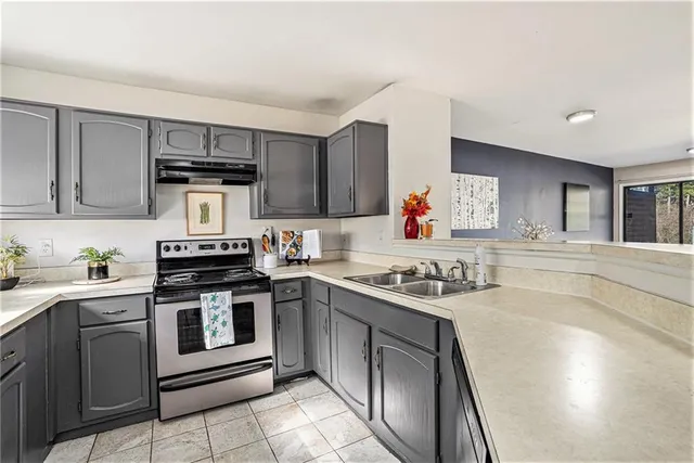 a kitchen with a stove sink and cabinets
