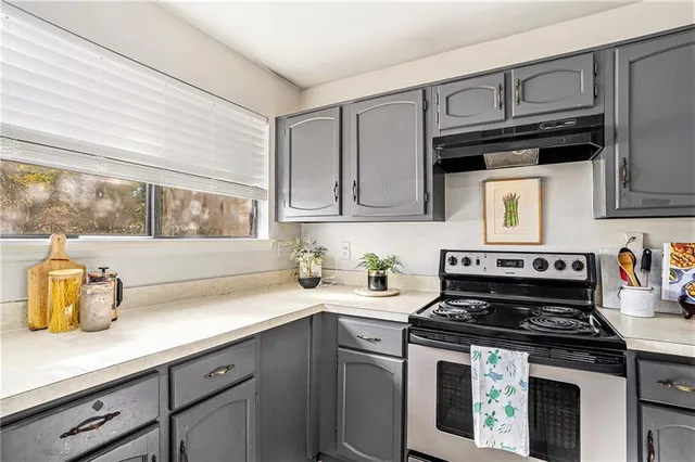 a kitchen with granite countertop a stove sink and cabinets