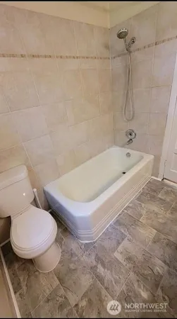 a white toilet sitting next to a bath tub and a shower