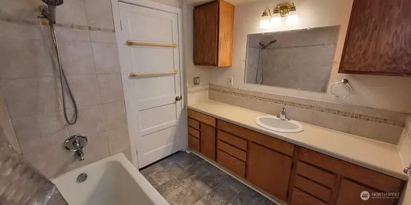 a bathroom with a tub sink and mirror