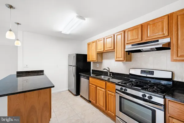 a kitchen with stainless steel appliances granite countertop a stove a refrigerator and a microwave