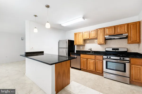 a kitchen with stainless steel appliances granite countertop a stove a sink and a refrigerator