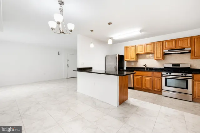 a kitchen with stainless steel appliances granite countertop a stove and a refrigerator