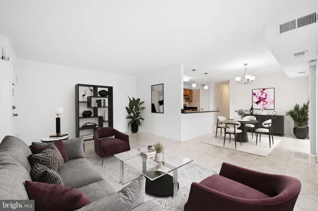 a living room with furniture kitchen view and a window