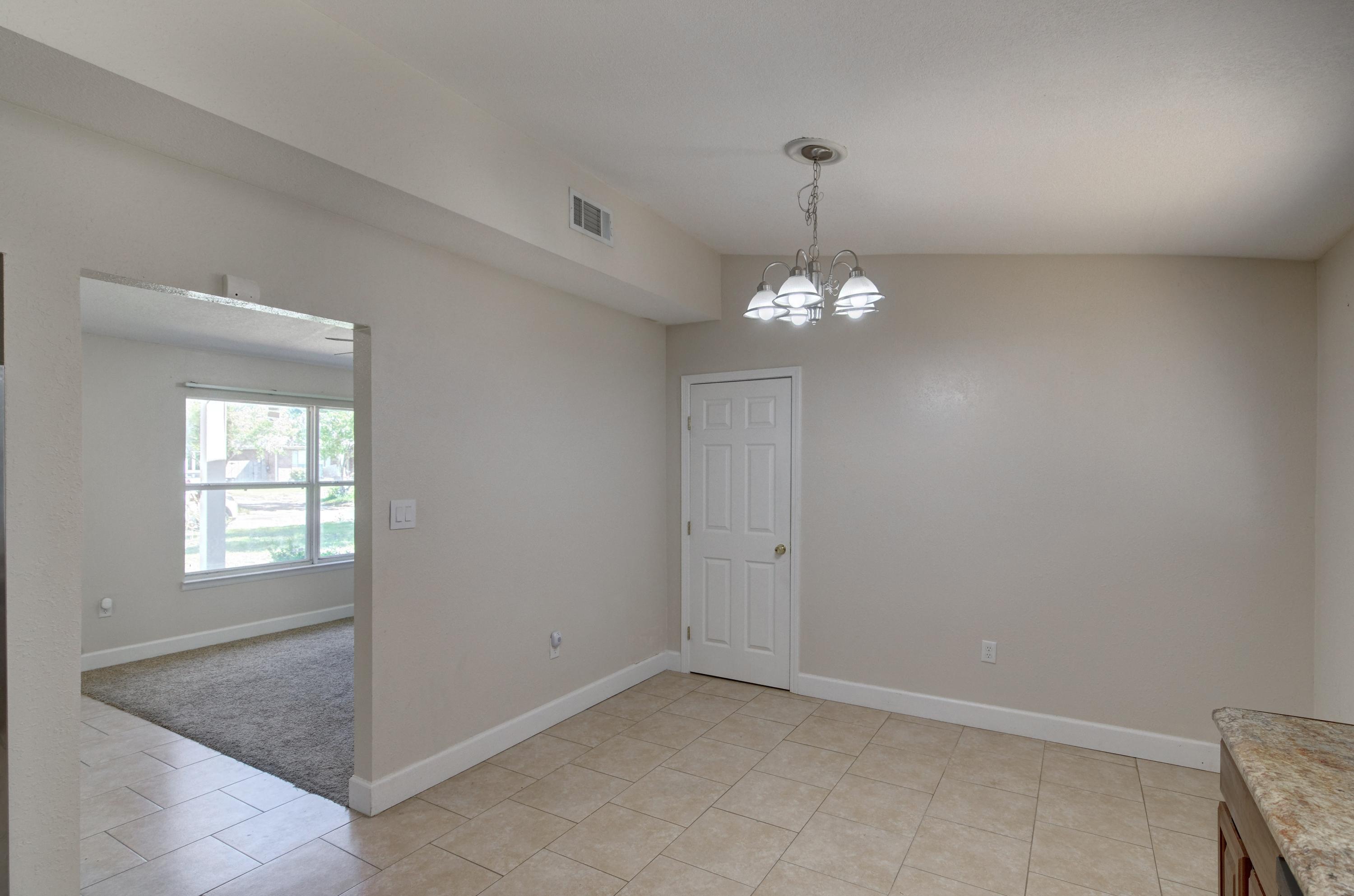 419 Westminster Road Fort Walton Beach, FL 32547 - Photo 14 of 40 en empty room with windows and chandelier