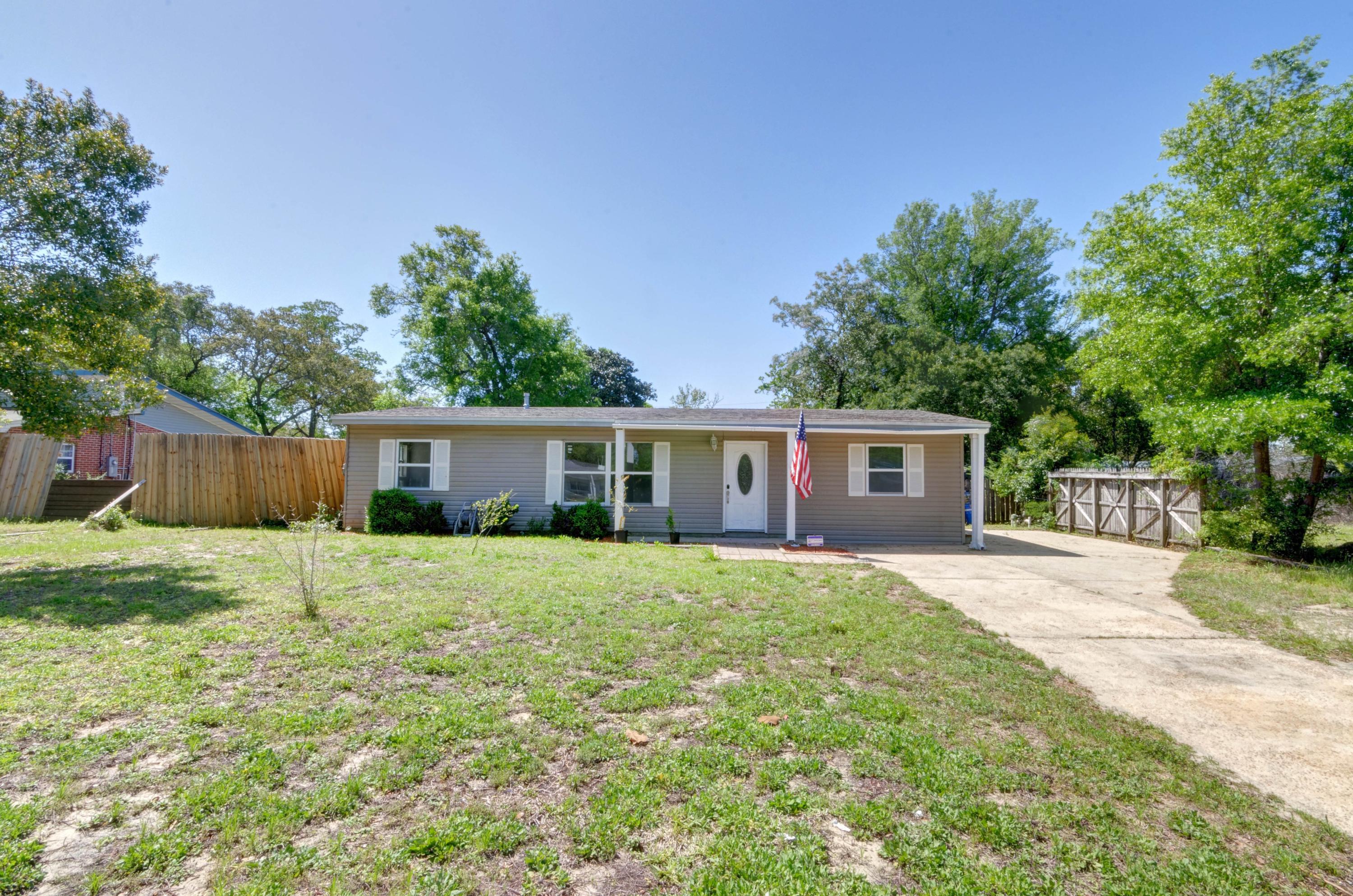 419 Westminster Road Fort Walton Beach, FL 32547 - Photo 39 of 40 a house that is sitting in the grass with large trees and wooden fence